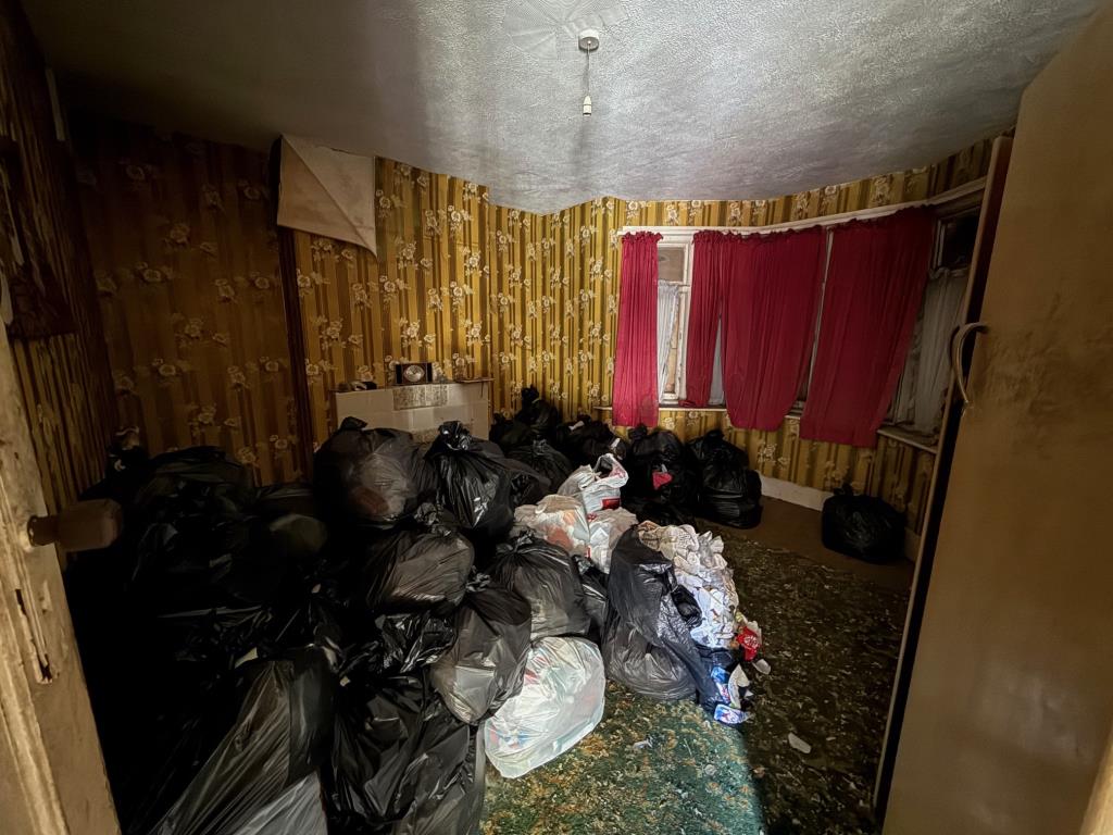 Lot: 170 - HOUSE FOR COMPLETE REFURBISHMENT - Living room with black bags of possessions